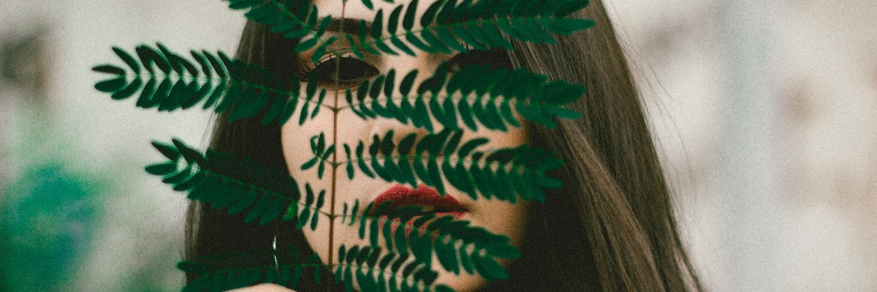 Masking Mental Illness With the Facade of Being OK woman with leaf