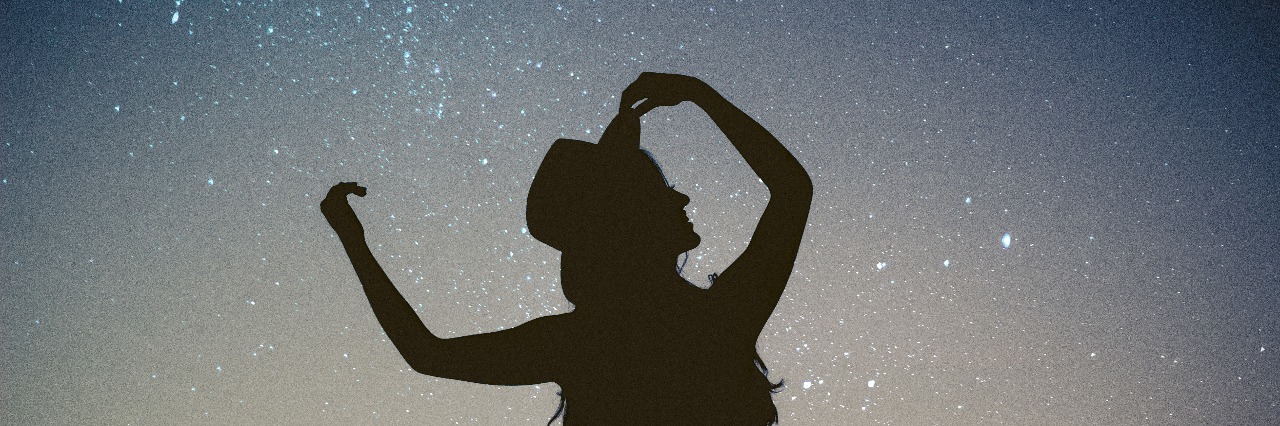 woman silhouetted against starry night sky