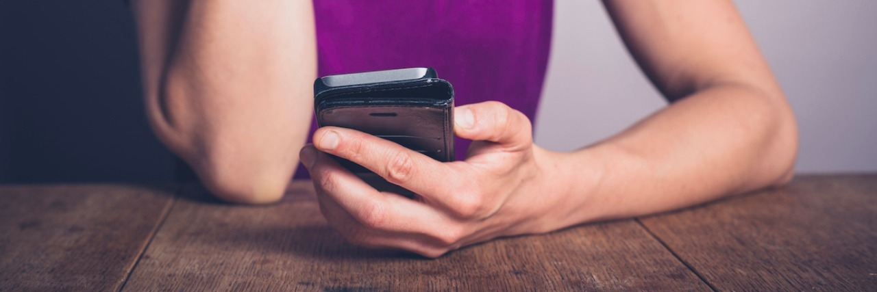 18 Worries of Someone With Anxiety When Their Friend Doesn't Text Back A woman looking at her phone. Text reads: 18 worries of someone with anxiety when their friend doesn't text back