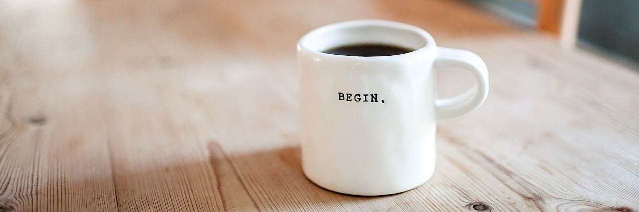 cup of coffee on table with word begin on mug