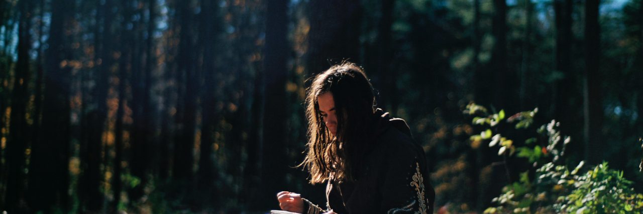 girl in the woods journaling