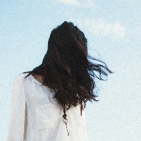 young woman with hair covering face against sky backdrop