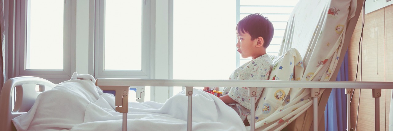 Caring for My Child With Chronic Illness Side shot of a boy sitting on his hospital bed