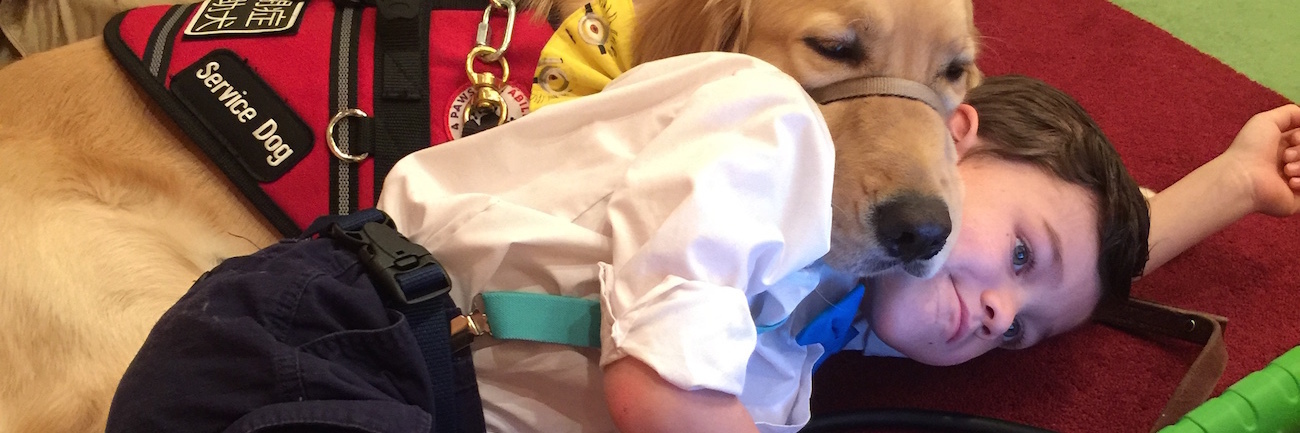 Taking My Autistic Son and His Service Dog to Meet Vice President The author's son Kai and Tornado his service dog lying on the carpeted floor, watching an iPad