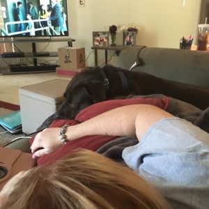 woman lying on couch watching tv