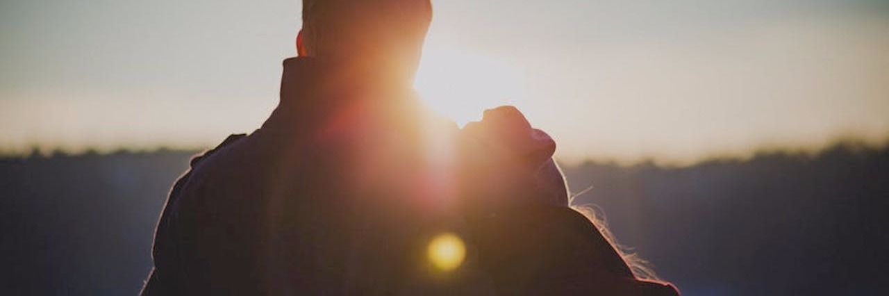 Ups and Downs of Dating With Multiple Sclerosis man and woman looking at sunset over snowy landscape