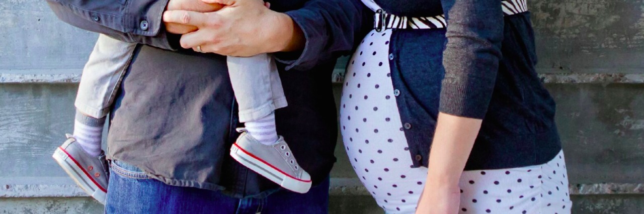 Letter to Myself After My Daughter's Congenital Heart Defect Diagnosis Photo of dad holding child and pregnant mom standing next to them