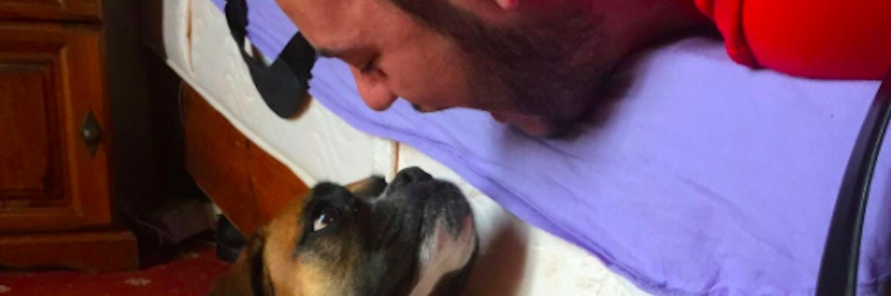 To Grieve Is to Love Man lying on bed, looking down with face toward dog's face, which is lying on the ground next to the bed