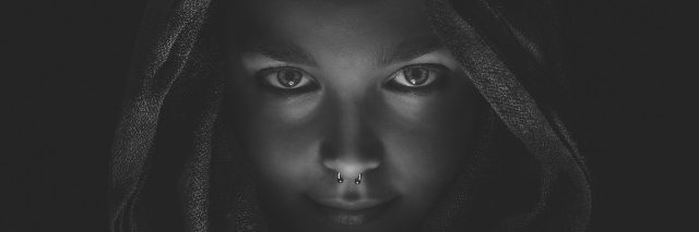 young woman black and white wearing nose ring looking confident at camera