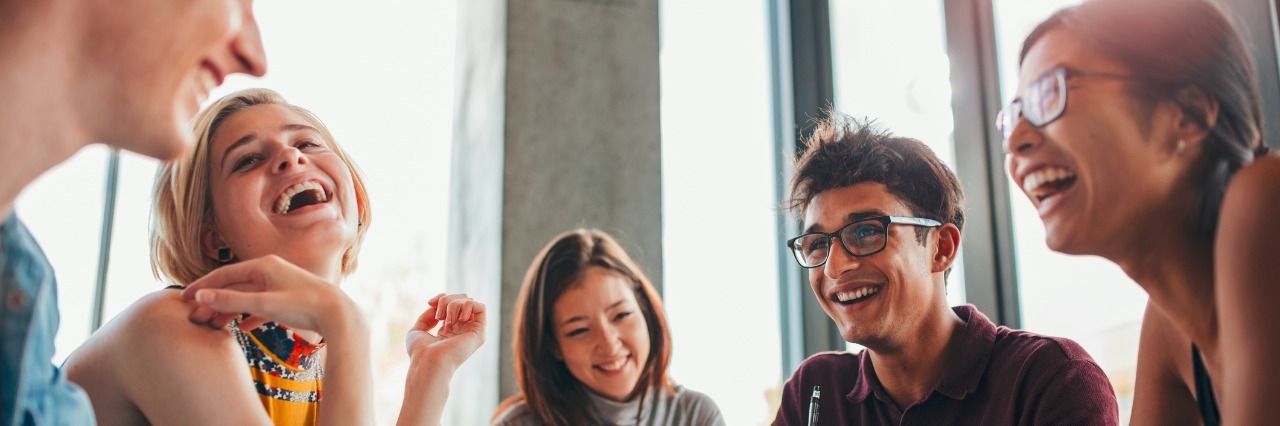 How Speech Therapy Helped Me Accept My Stutter Five college students sitting around a table and laughing