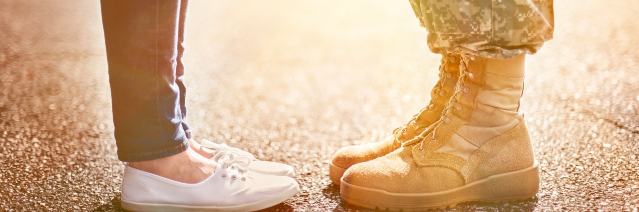 The Anxiety I Feel When My Husband Is Away on Military Assignment Young military couple kissing each other, homecoming concept, soft focus,warm orange toning applied