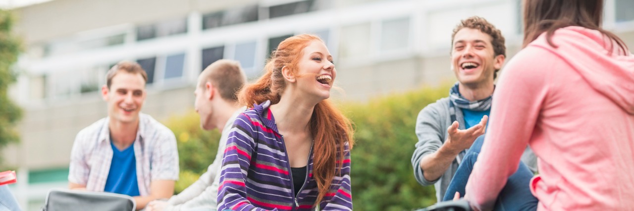 What Helped Me Get the 'University Experience' With My Mental Illness Image of 5 University students sitting on a lawn and talking to each other