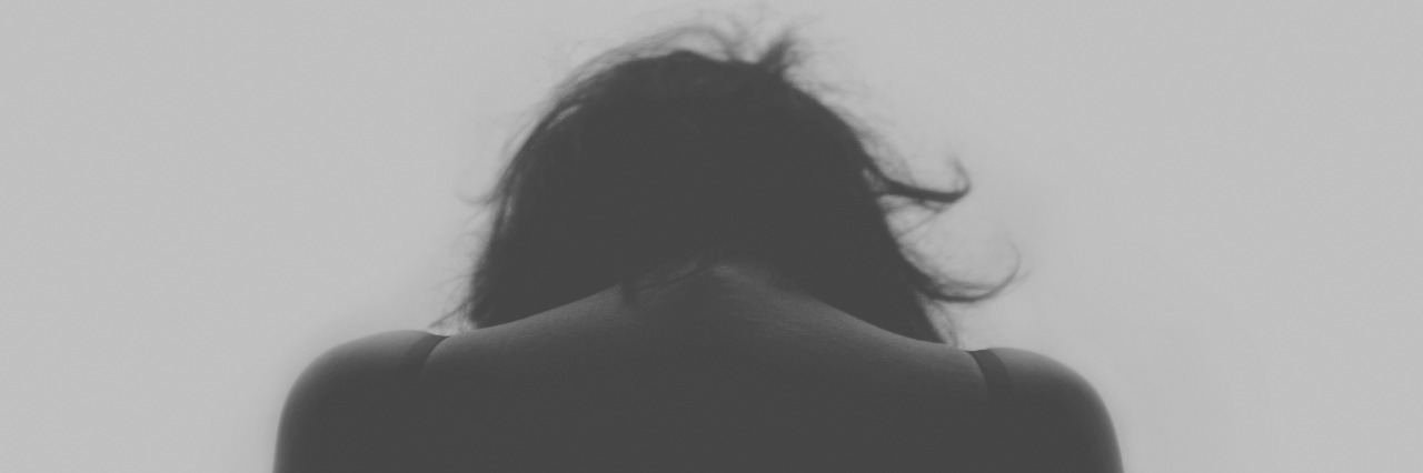 This Is the Reality of Living With Depression black and white photo of girl looking down from behind