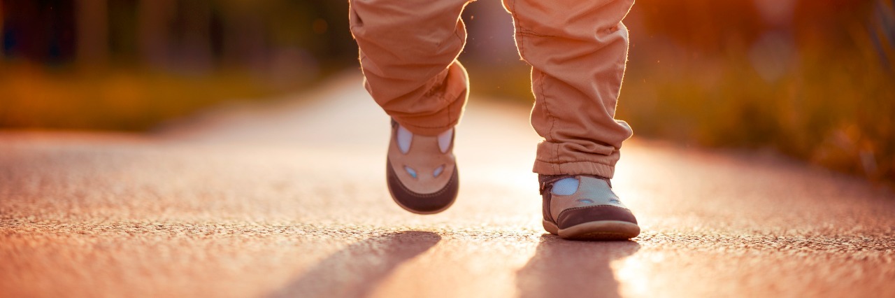 The Excitement of Reaching Milestones for My Son With Down Syndrome Little legs walking down a path