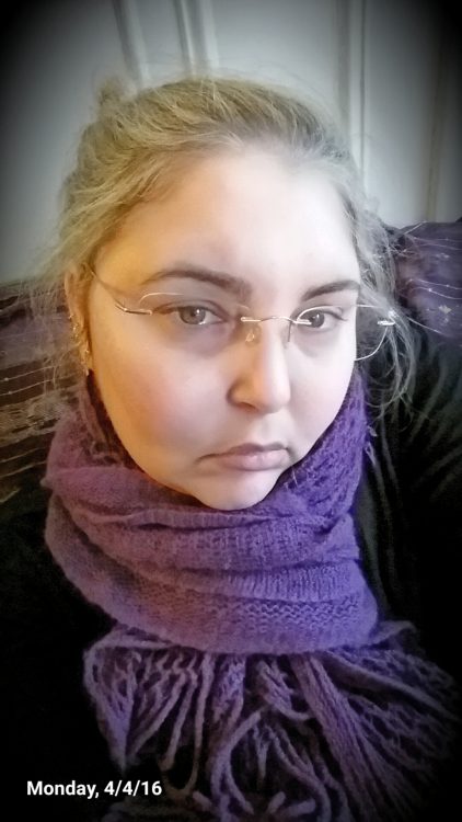 selfie of a woman with glasses and a purple scarf
