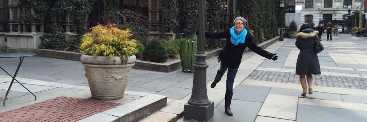 Please Don't Call Me 'Brave' for Having Congenital Heart Disease woman hanging on to street lamp in new york city