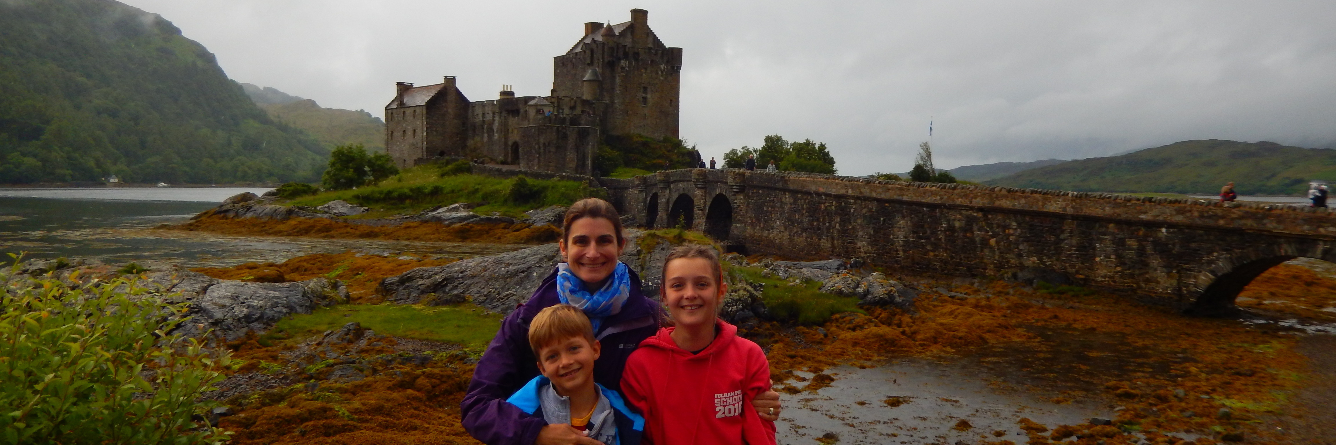 mother and two children at eilean donan castle in scotland