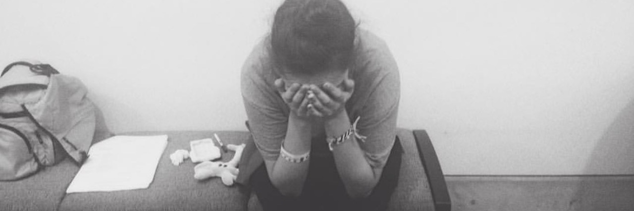 Holding Onto Hope With Chronic Illness black and white photo of a woman sitting on a table looking distraught