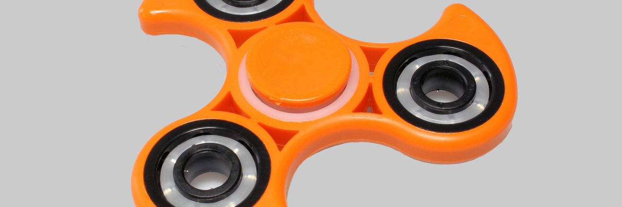 Schools Across the Country Ban Fidget Toys, Autism Community Responds Photo of an orange fidget spinner