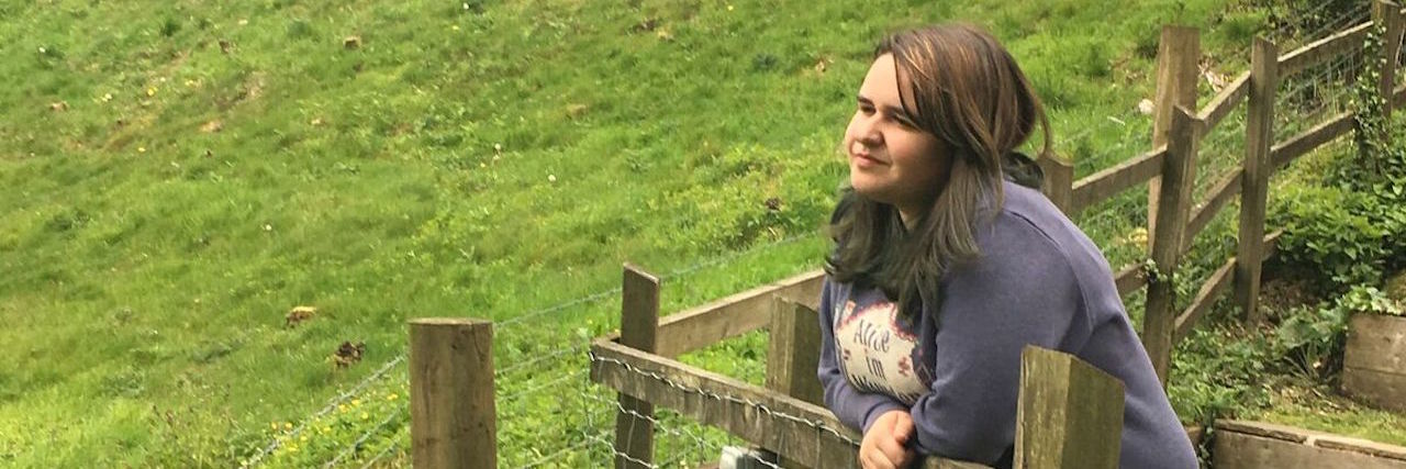Why You Shouldn't Tell Someone With a Disability They're 'Strong' woman leaning on a railing looking at a park