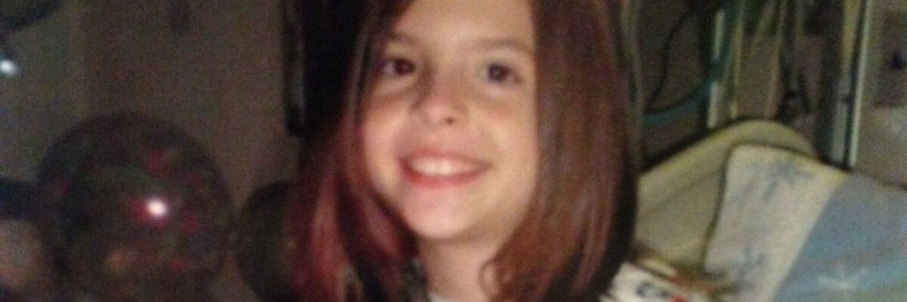 What I Wish I Knew When I Was Diagnosed With Crohn's Disease young girl sitting in a hospital bed with a stuffed animal