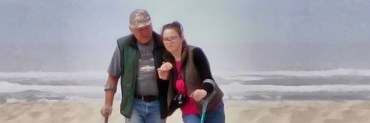 To Children With Cerebral Palsy: You've Got a Friend Kelcie walking on the beach with a relative.