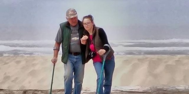 To Children With Cerebral Palsy: You've Got a Friend Kelcie walking on the beach with a relative.