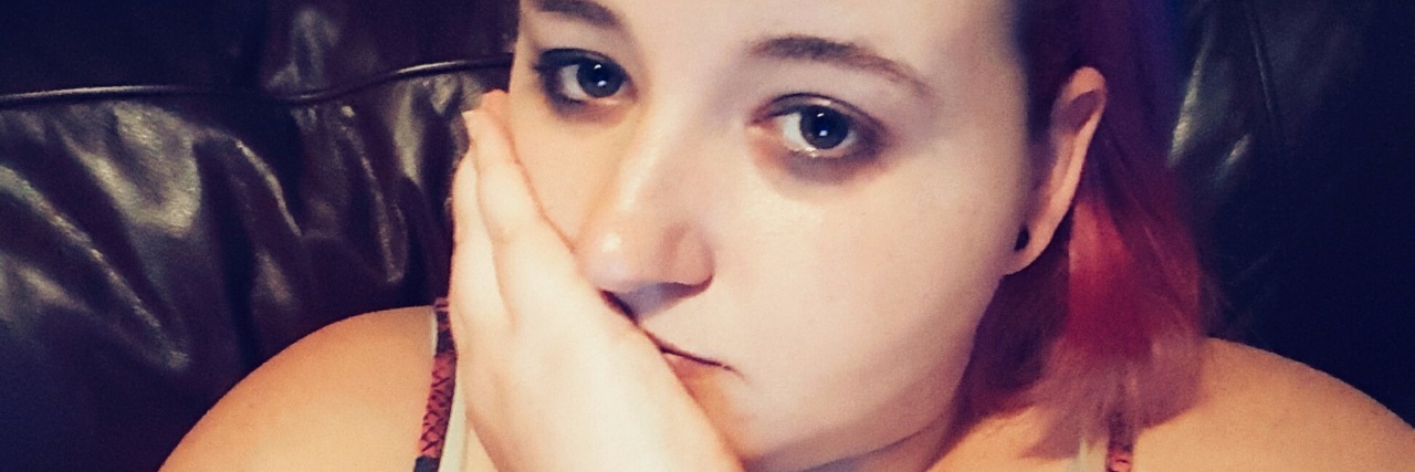 Calling for Emergency Medical Help With Chronic Pain a woman's selfie of her frowning and leaning on her hand