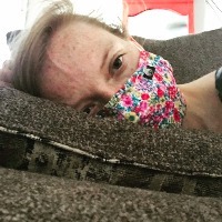 aubrey winkie laying on couch wearing surgical mask