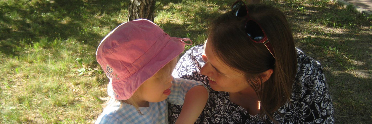 Mothers Adopting Children With Disabilities Lilya, a little girl wearing a yellow shirt and smiling.