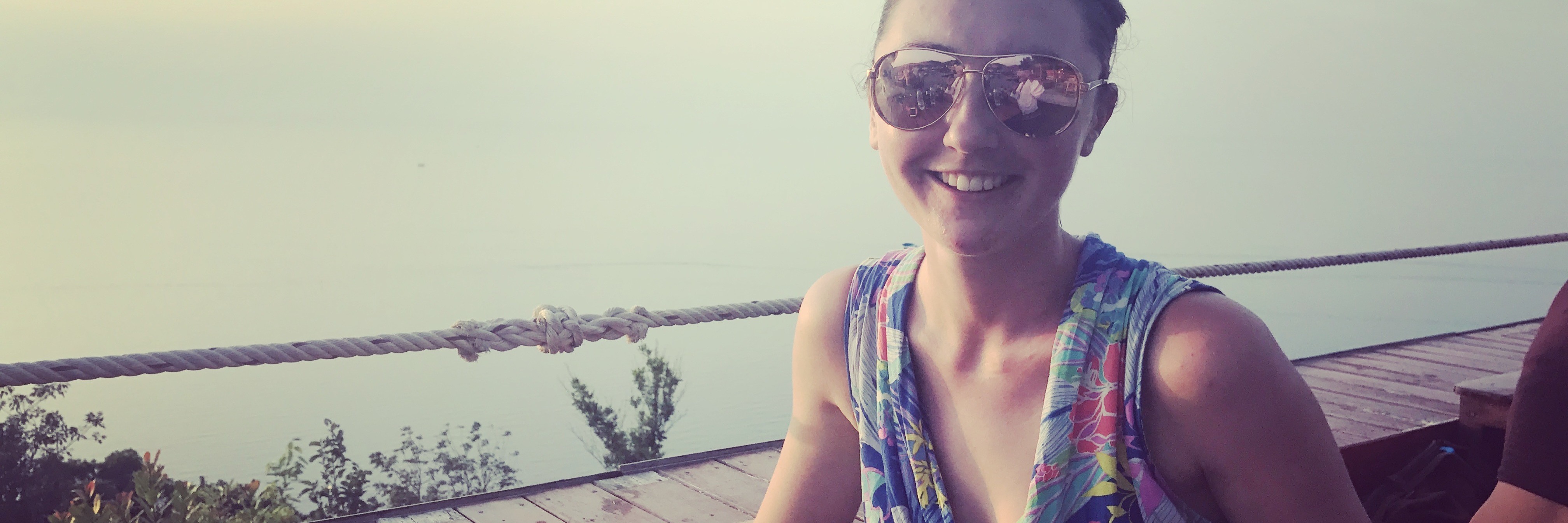 When Anxiety Follows You Around the World young woman on balcony wearing sunglasses in tropical location
