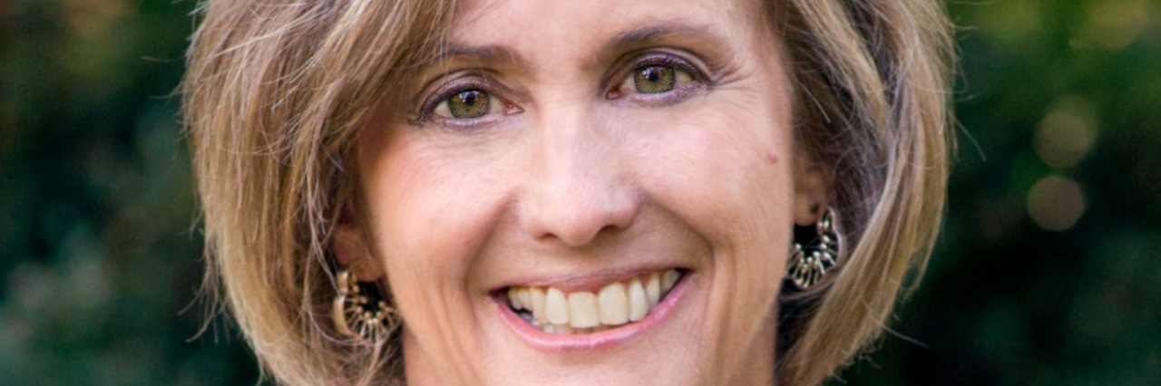 Revisiting My Cancer Journal, 30 Years After My Cancer Diagnosis Woman smiling, in front of tree background