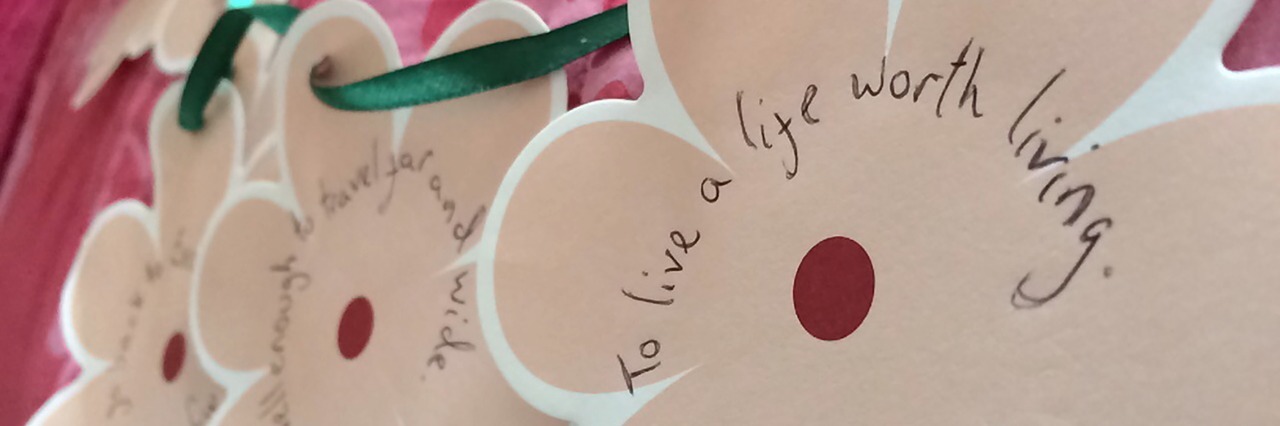 I Keep Choosing Life: A Poem on Recovery from Anorexia contributor image showing recovery messages written on ornate cards in the shape of flowers tied together with ribbon