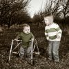 Boy with walker and sister playing in an orchard.