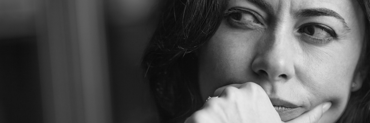 Close-up portrait of a pensive woman. low key.