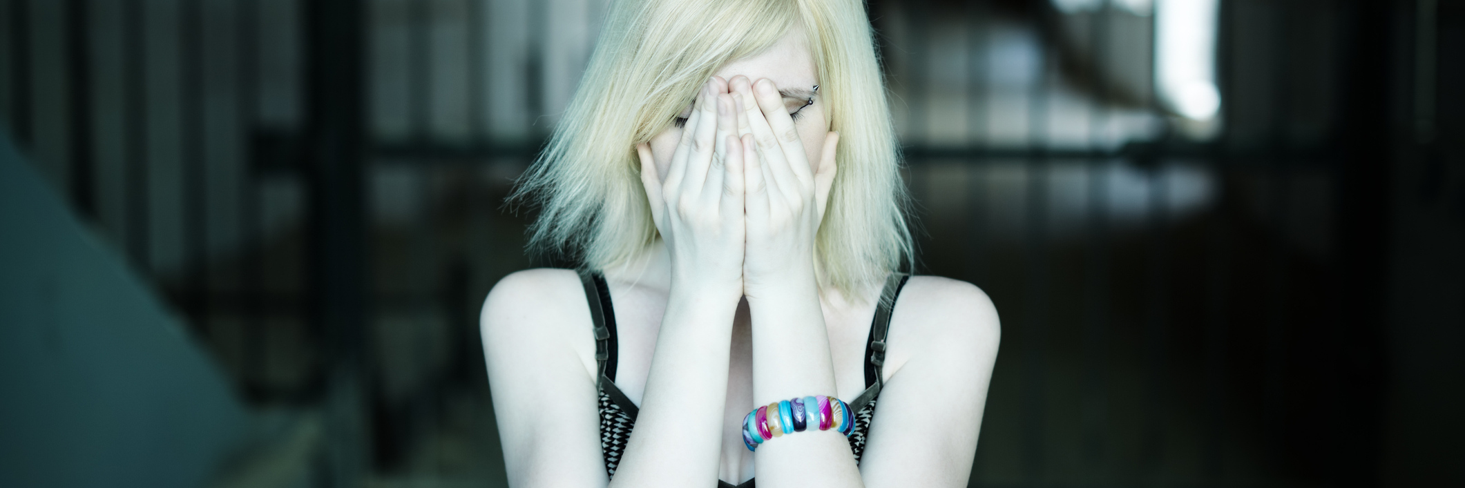 Infographic About Paranoia and Schizophrenia Signs, Causes, Treatments woman in dark hallway with hands covering face and eyes looking upset