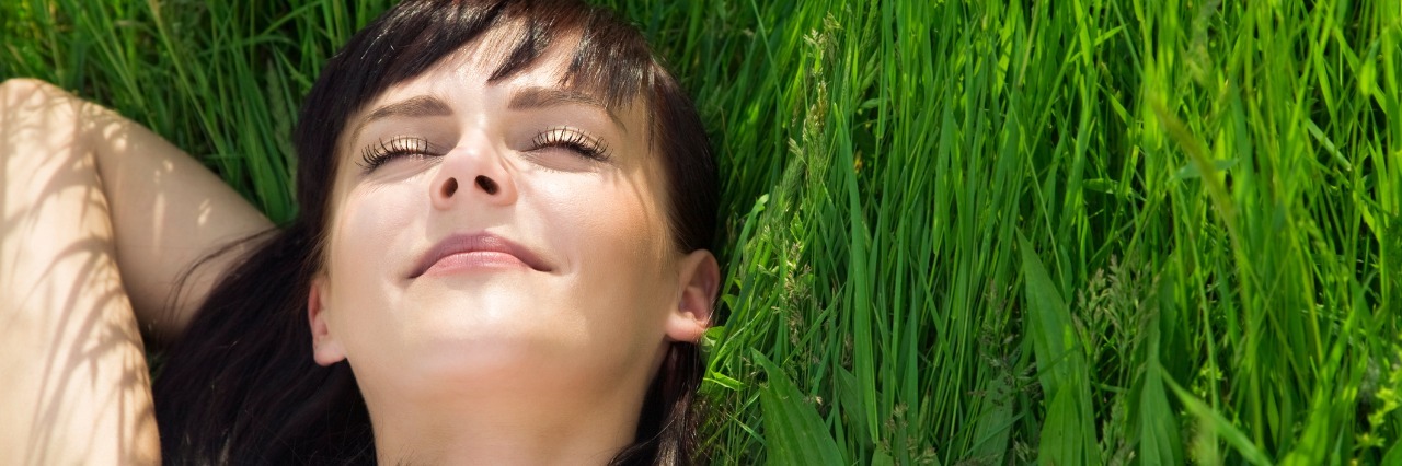 woman lying down on the grass and smiling