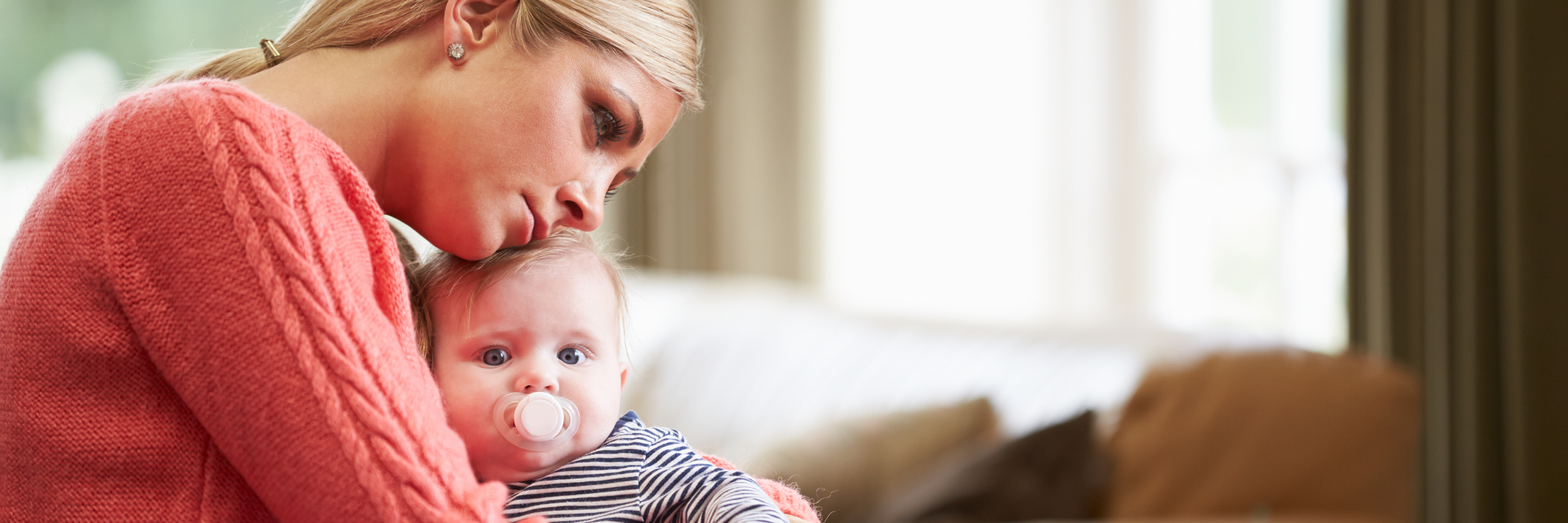 Obsessed Over Ways Baby Could Die: Living With Postpartum OCD mother holding young baby looking upset