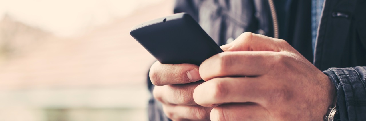 Sites to Try When You're Too Cynical for Traditional Mindfulness Close up of a man using mobile smart phone