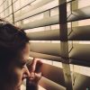 woman peeking through her blinds