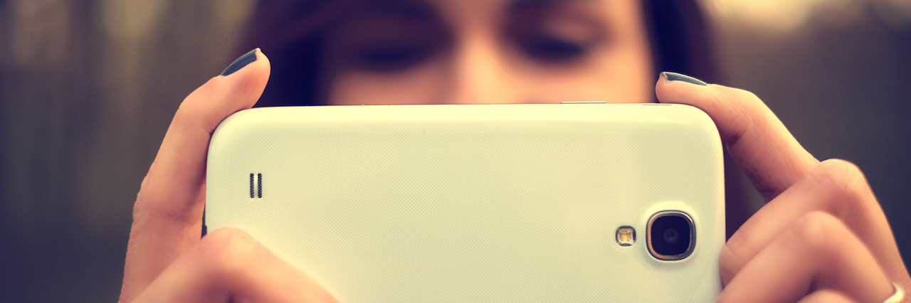 Postpartum Depression: Pressure to Be Perfect on Facebook A woman holding a phone