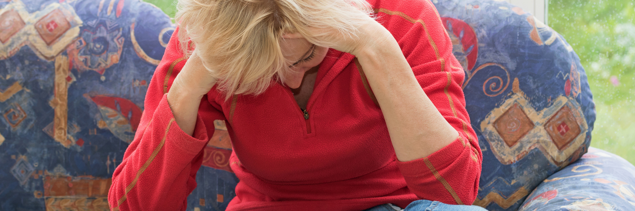 Frustrations of Pacing and Moderating Yourself With Chronic Illness woman sitting on the couch with her head in her hands, looking frustrated
