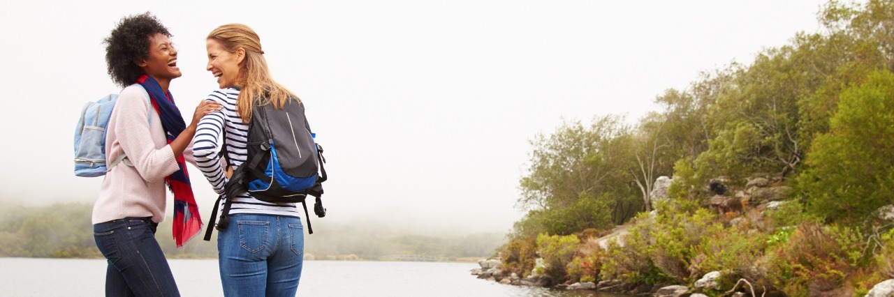 Lupus: The Power of Words in Encouraging Someone With Illness two female friends hiking near a lake and laughing