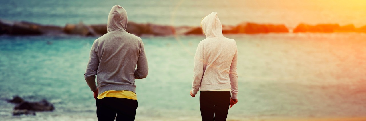 If You're Nervous to Show Your Self-Harm Scars This Summer.... A woman and a man waring long sleeves at the beach
