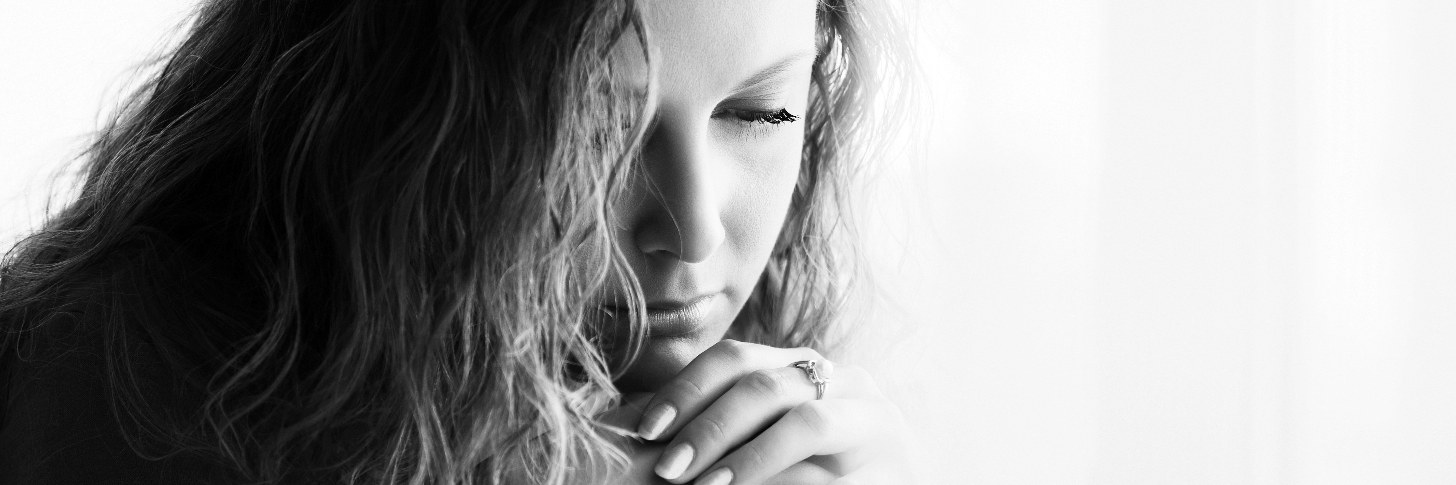 black and white image of young sad woman with long curly hair