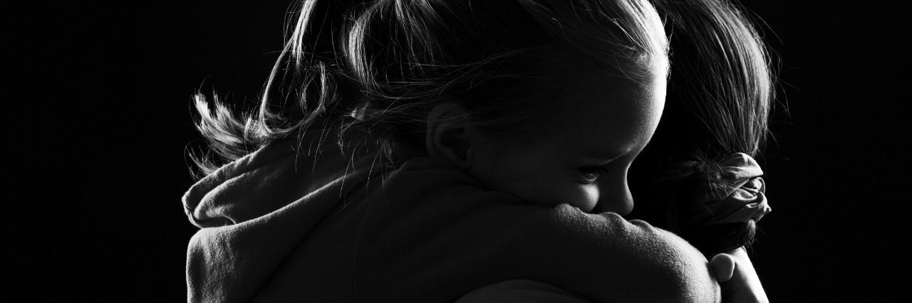 Advice for Mom of Child With an Illness Black and white image of a little girl hugging her mother