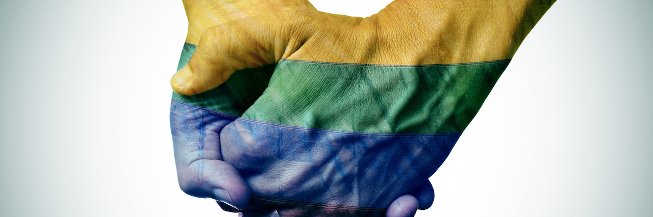 Gay, Mentally Ill and Coping With the Pulse Anniversary a couple holding hands painted rainbow