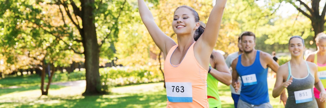 woman crossing the finish line of a race in first place