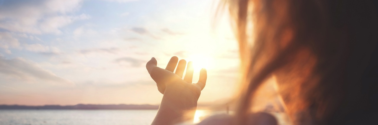 Crohn's Disease, Lupus: Embracing Hypertrophic Scarring woman standing in front of ocean at sunset