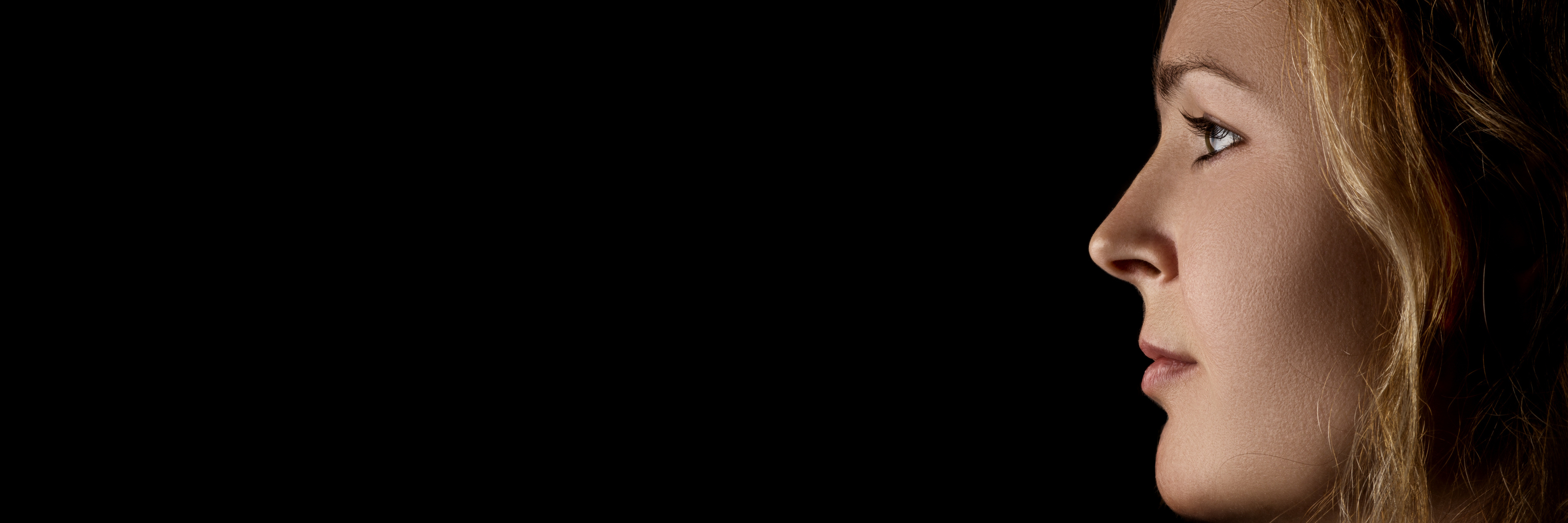 Why I Question If I Deserve to Recover From My Mental Illness profile of young pensive woman with red hairs on black background